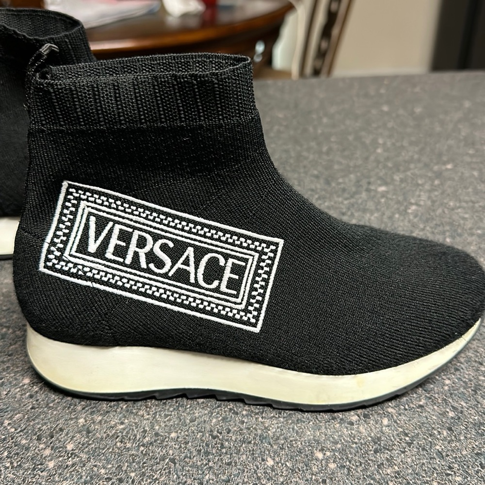Black Versace sneakers with white Versace logo.